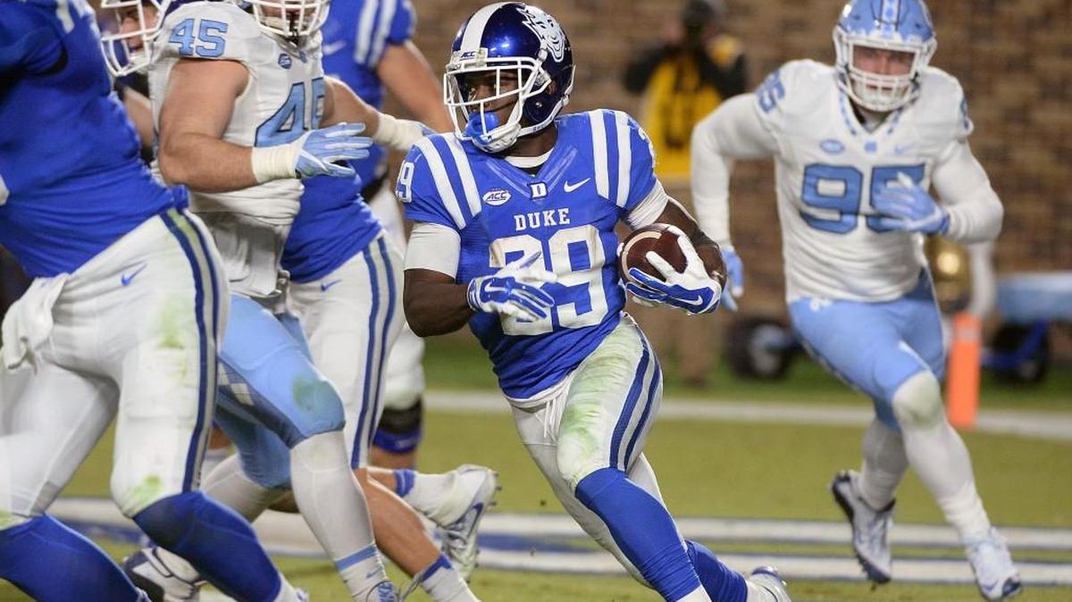 Duke running back Shaun Wilson, middle, heads for a first down against UNC in 2016.