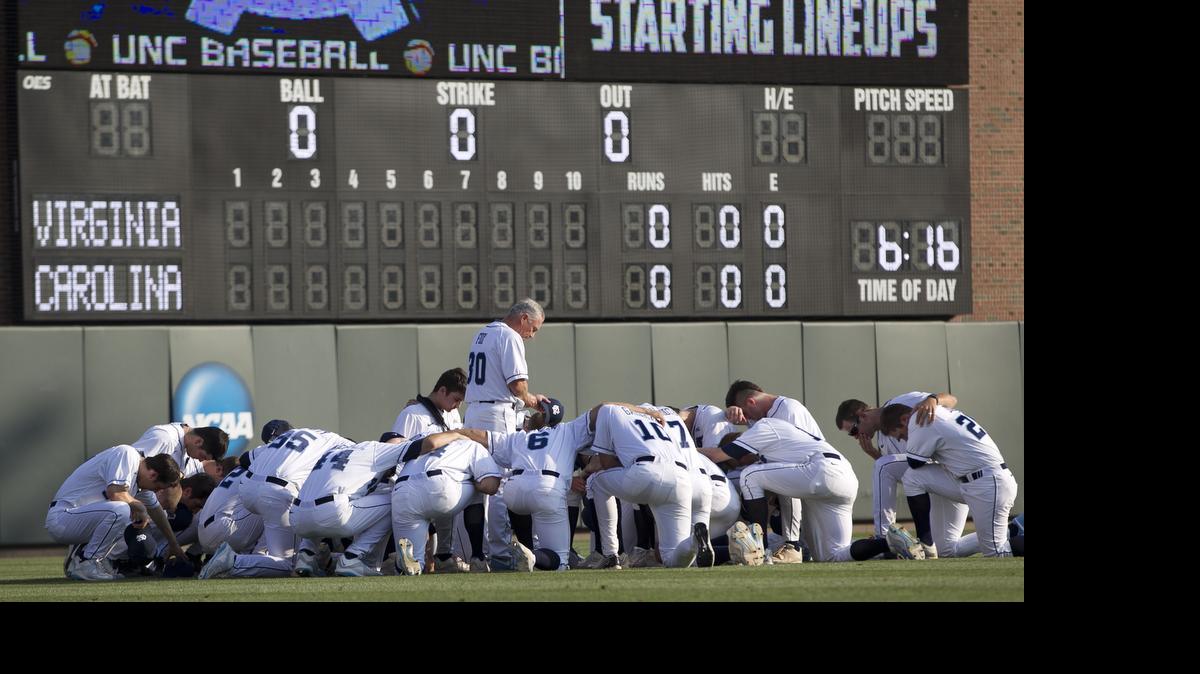 
North Carolina coach Mike Fox and his players gather for prayer in left field of Boshamer Stadium prior to their game against Virginia on Friday, May 15, 2015 in Chapel Hill, N.C. 
