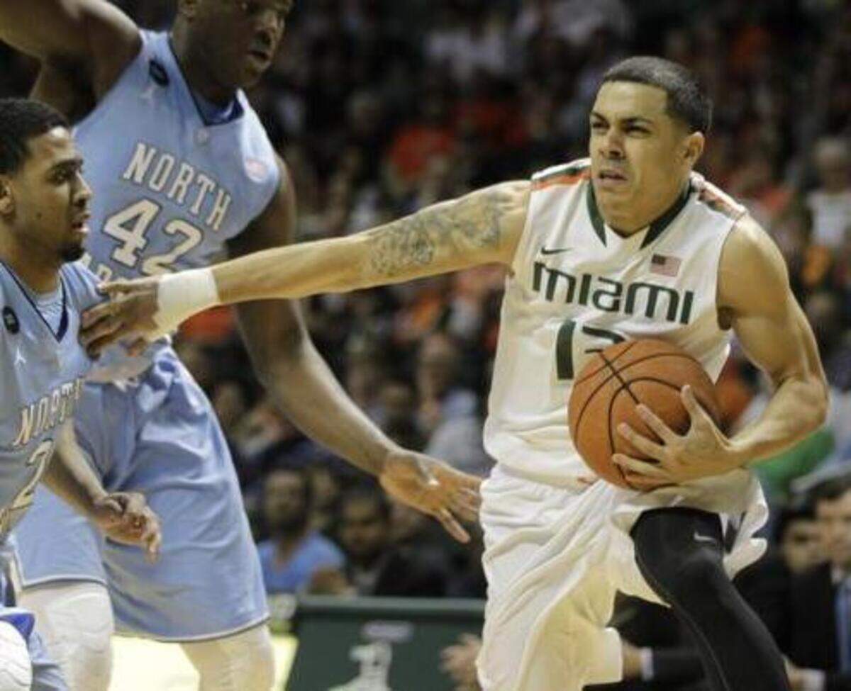 
Miami’s Angel Rodriguez, right, move the ball past North Carolina’s Joel Berry II (2) and Joel James (42) during the first half of an NCAA college basketball game, Saturday, Feb. 28, 2015, in Coral Gables, Fla. 
