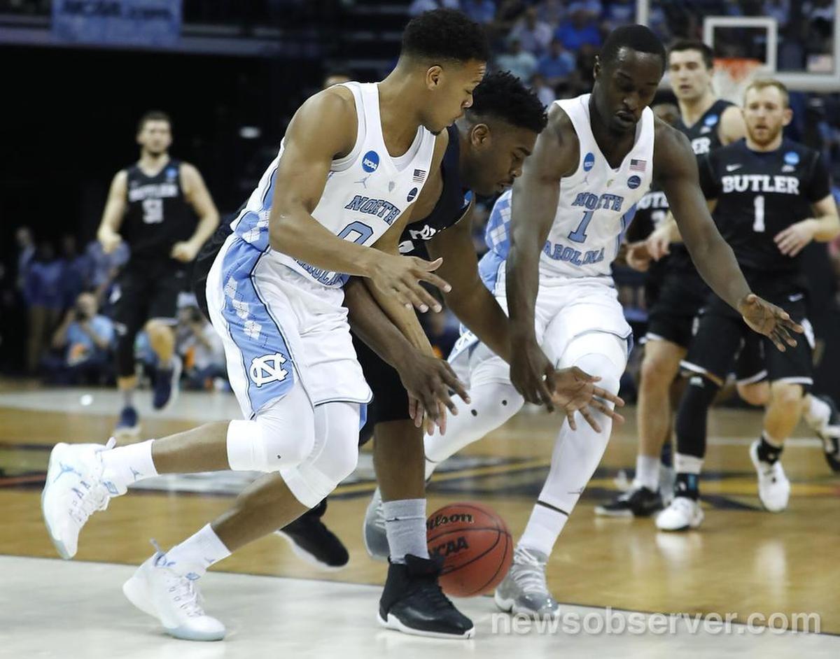 North Carolina's Nate Britt (0), left, and North Carolina's Theo Pinson (1) knock the ball from Butler's Kelan Martin (30) during the first half of UNC's game against Butler in the NCAA Tournament South Regional semifinal at FedExForum in Memphis, TN Friday, March 24, 2017.