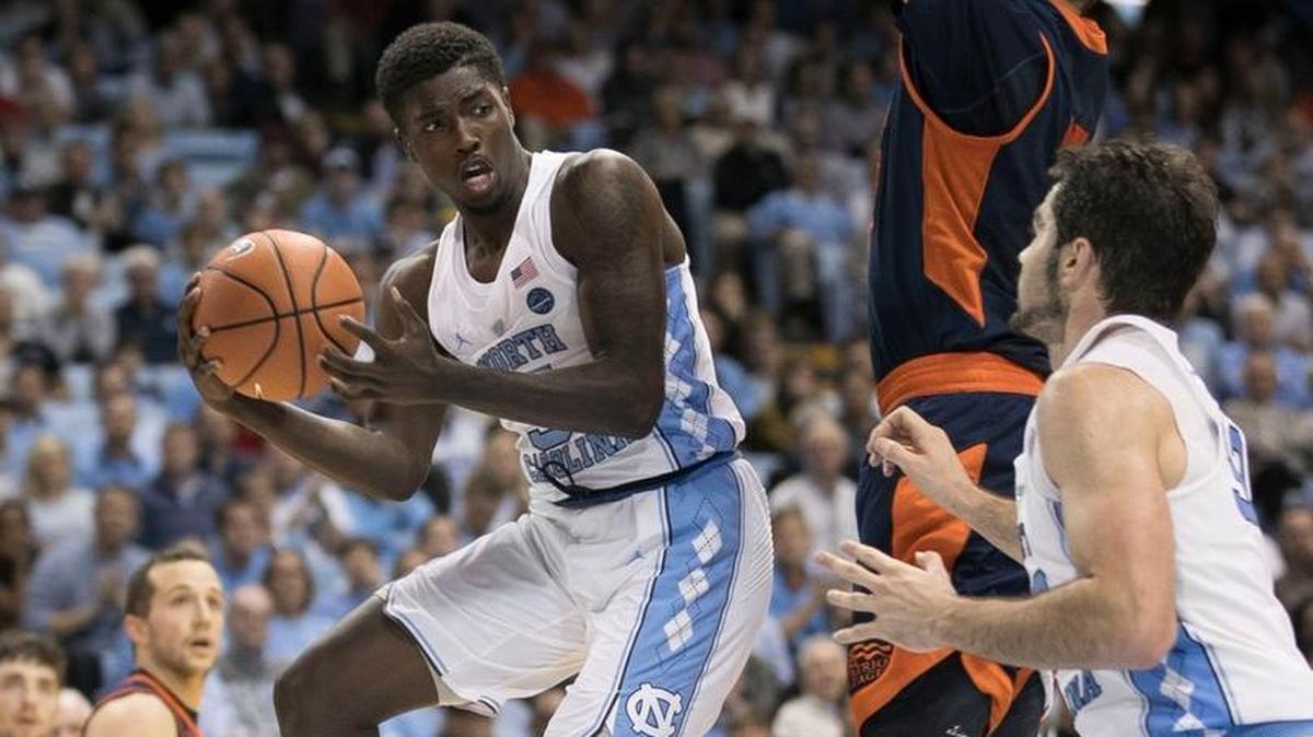 North Carolina’s Jalek Felton, left, passes around Bucknell’s Bruce Moore, middle, to teammate Luke Maye on Nov. 15.