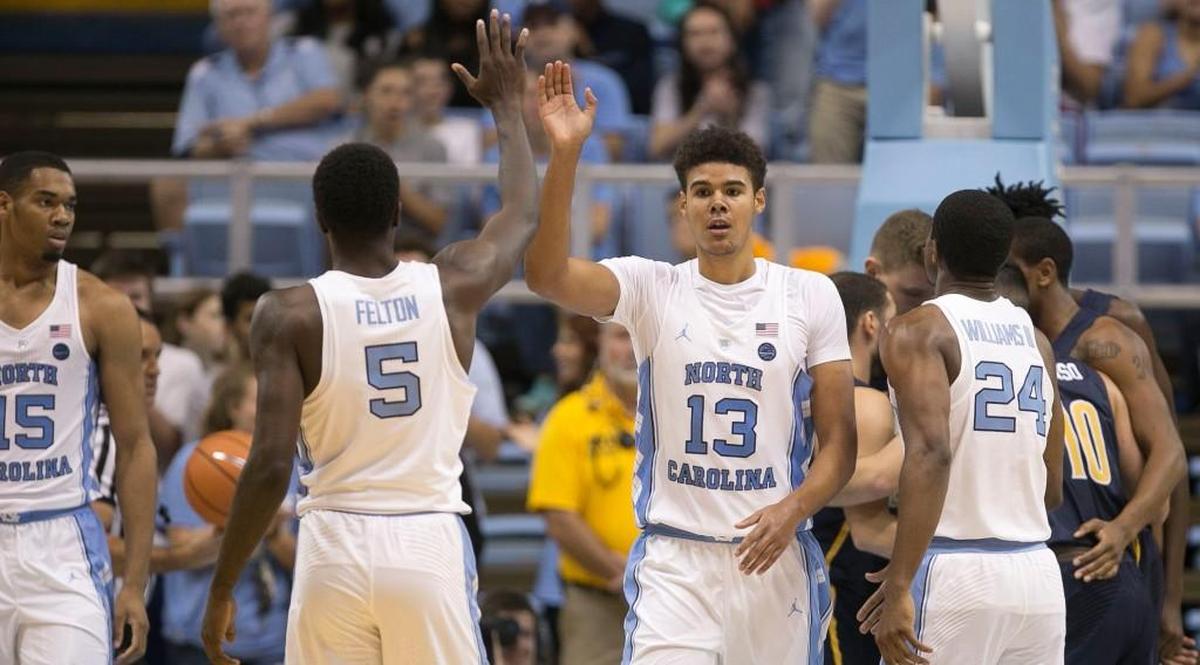 North Carolina’s Jalek Felton, 5, congratulates teammate Cameron Johnson, middle, after Johnson sank a basket and drew a foul against UNC-G during the North Carolina Disaster Relief Jamboree on Nov. 5.