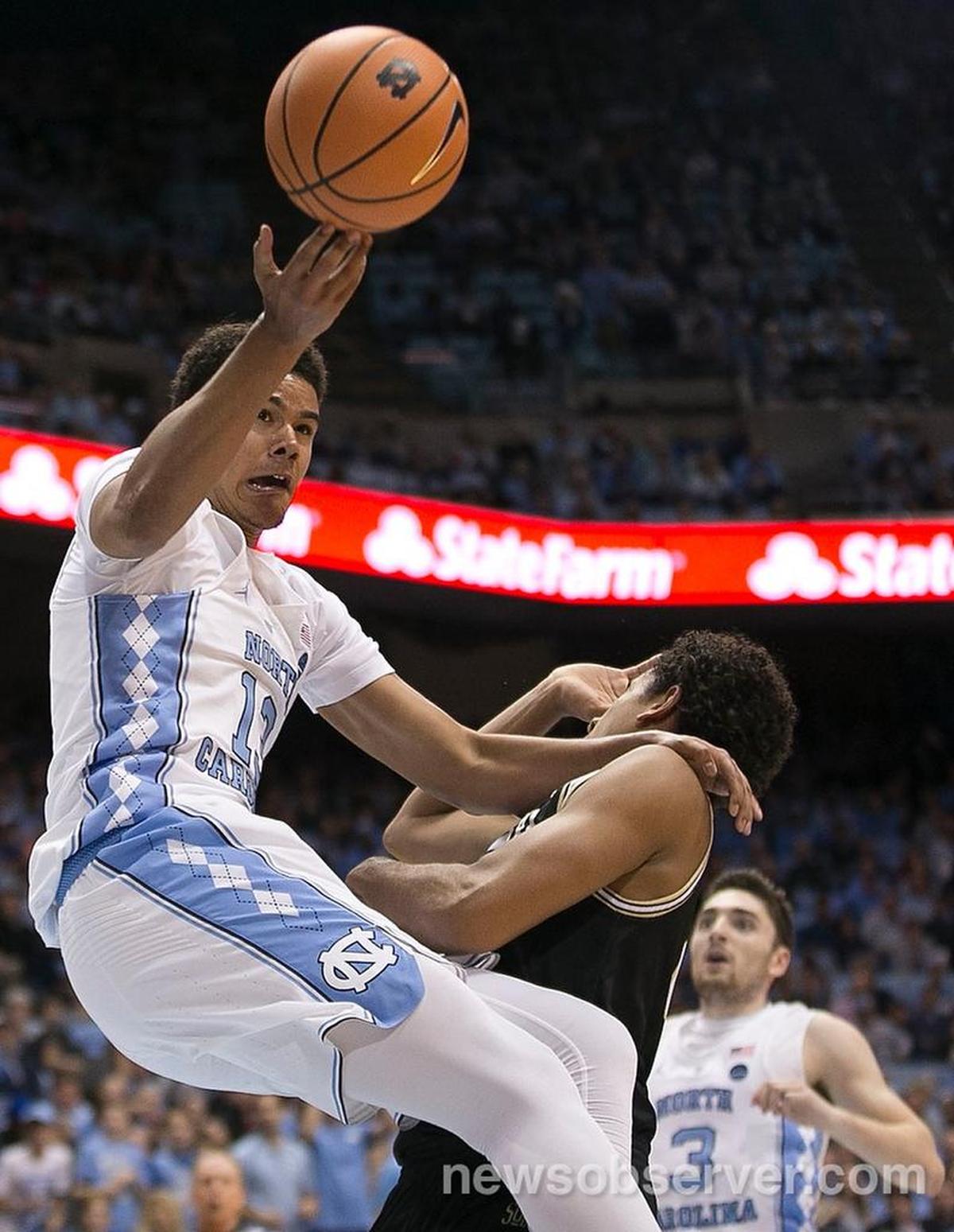 North Carolina’s Cameron Johnson (13) collides with Wofford’s Keve Aluma (24) on a fast break during the first half on December 20, 2017 at the Smith Center in Chapel Hill.