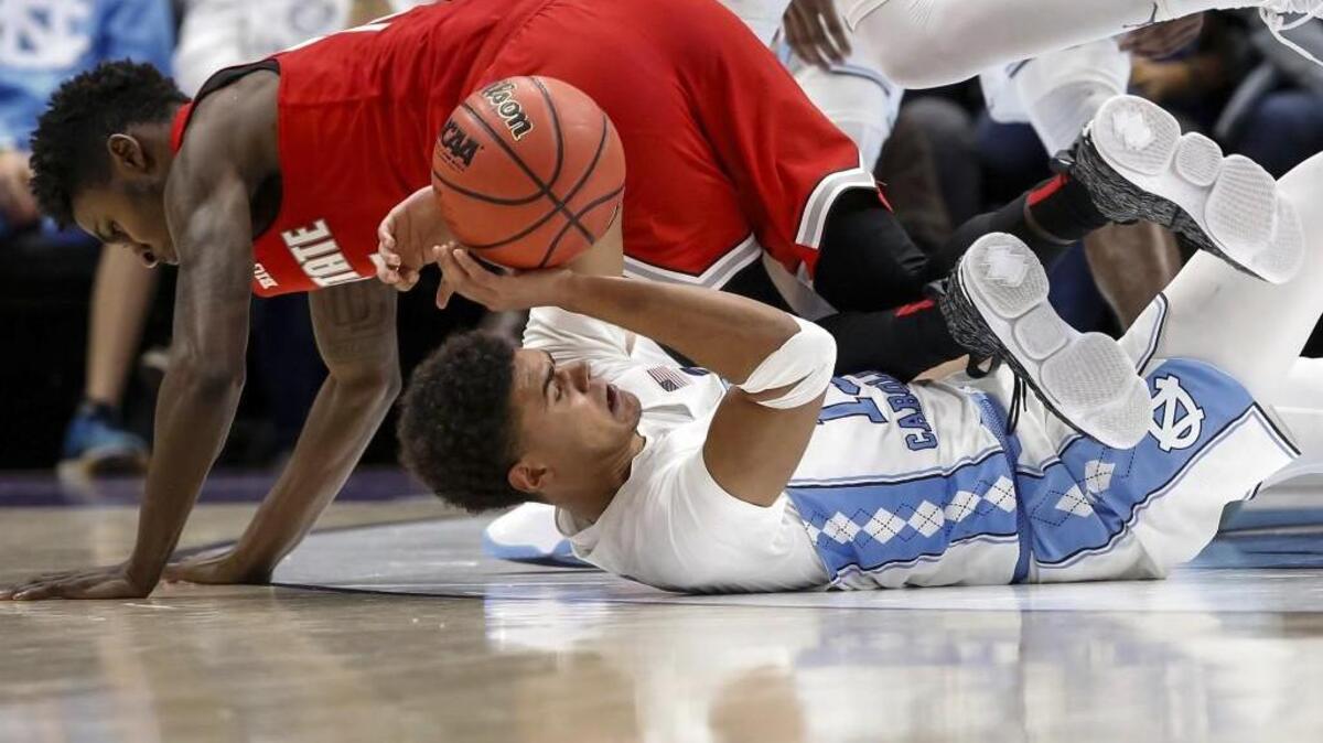 North Carolina guard Cameron Johnson (13) grabs a loose ball against Ohio State guard Kam Williams (15) in the second half of an NCAA basketball game in New Orleans, Saturday, Dec. 23, 2017. North Carolina won 86-72. (AP Photo/Scott Threlkeld)