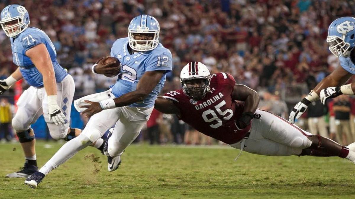 
North Carolina quarterback Marquise Williams (12) is slowed by South Carolina's Dante Sawyer (95) and sacked by the South Carolina defense for a 6-yard loss on the Tar Heels’ final drive of the game late in the fourth quarter in the Belk College Kickoff on Thursday, September 3, 2015 at Bank of America Stadium in Charlotte.
