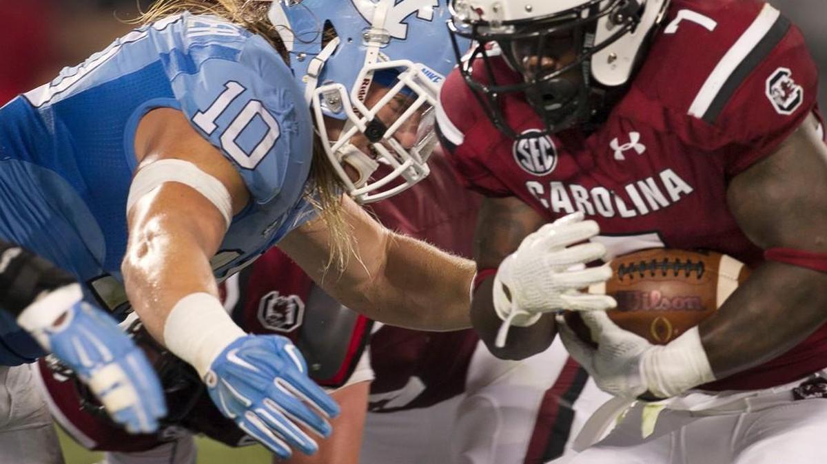 
North Carolina linebacker Jeff Shoettmer (10) stops South Carolina tailback Shon Carson (7) after a gain of 2 yards in the fourth quarter during the Belk College Kickoff at Bank of American Stadium in Charlotte.
