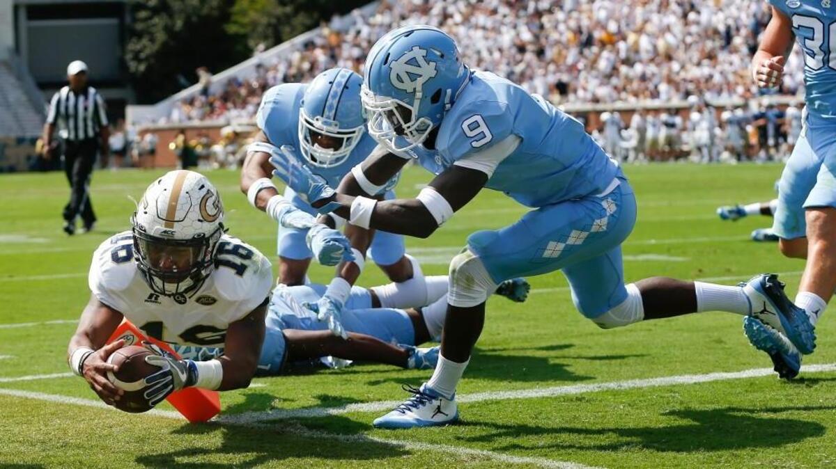 Georgia Tech quarterback TaQuon Marshall (16) dives into the end zone for a touchdown against North Carolina's Dominique Ross (3) and K.J. Sails (9) in the first half.
