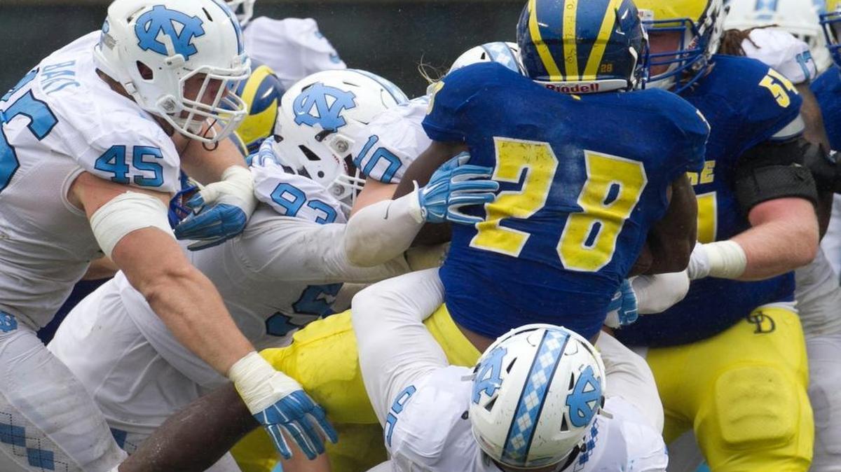 
Delaware’s Thomas Jefferson (28) is stopped by North Carolina’s Tyler Powell (95), Jeff Schoettmer (10) and Robert Dinkins (93) after a three-yard gain in the fourth quarter Sept. 26 in Chapel Hill.
The Tar Heel’s defensive line, which struggled against the Blue Hens, needs to improve before it faces Georgia Tech on Oct. 3. 
