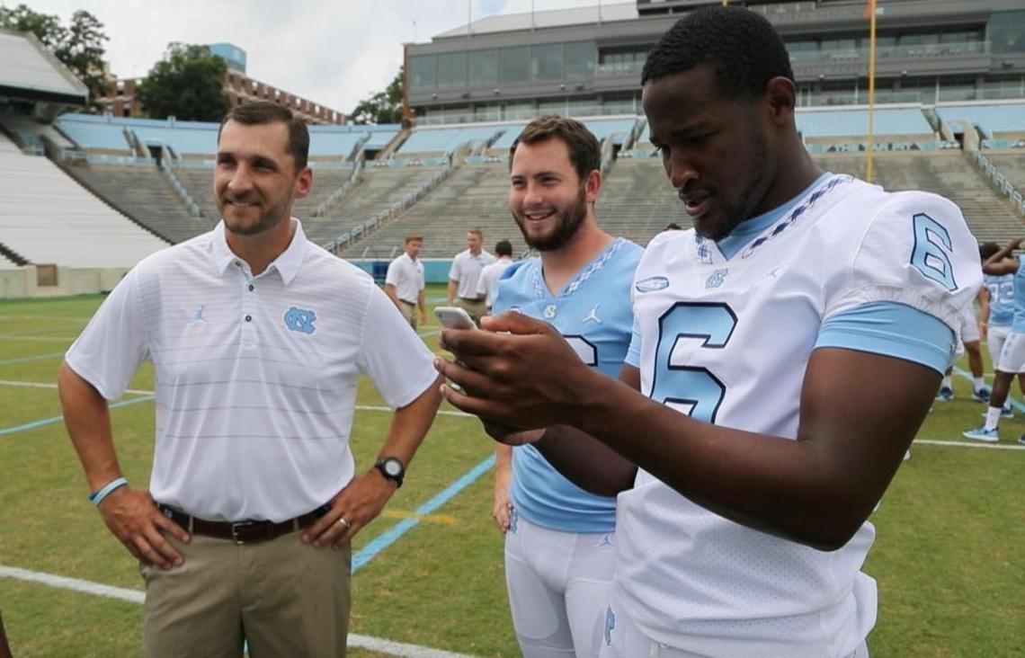 North Carolina quarterbacks coach Keith Heckendorf and quarterbacks Brandon Harris, center, Manny Miles, right, wait for a group photo at UNC’s media day on Monday.