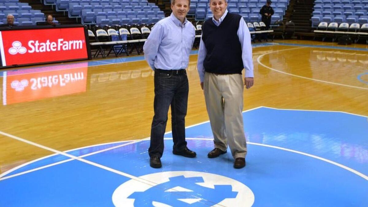 Bryan Crocker, right, and Ryan Bolick, left, stand on the court at the Smith Center in Chapel Hill. Crocker and Bolick met reporter Andrew Carter at a restaurant in the Bahamas in 2012, when Bolick and Crocker were there to see the Tar Heels after Crocker was diagnosed with terminal cancer. Crocker died in November.