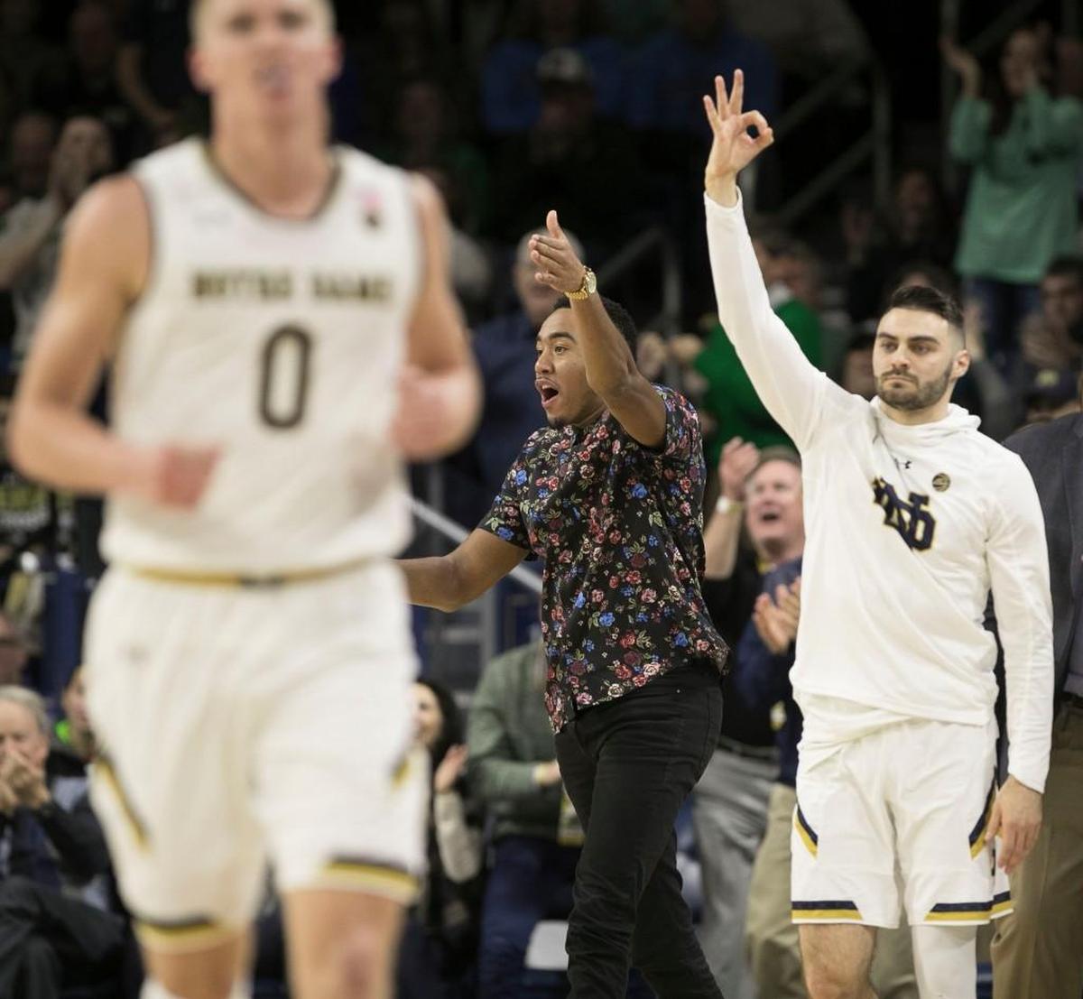 Notre Dame’s Matt Farrell (5), right, and Bonzie Colson (35), center, both out with injuries, cheer on their teammates after taking the lead over North Carolina on Saturday, January 13, 2018 at the Joyce Center in South Bend, Indiana.