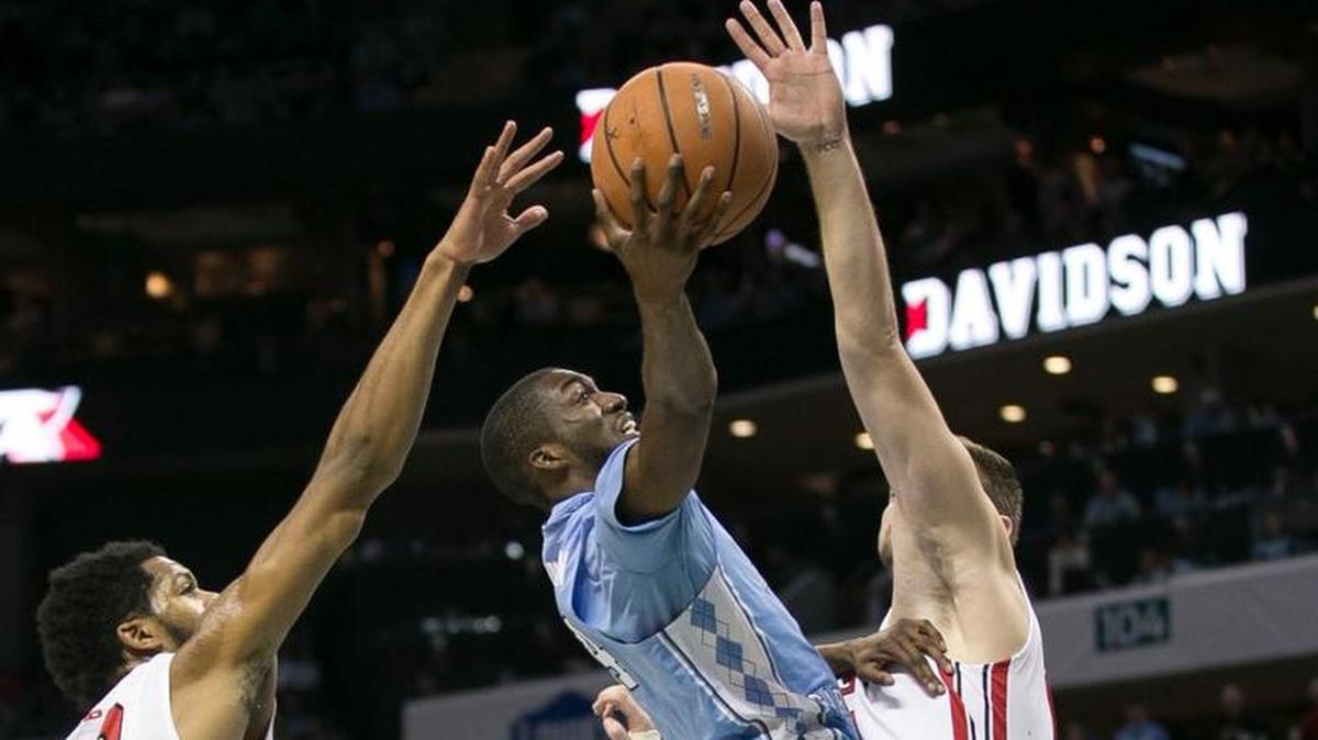 North Carolina’s Brandon Robinson, middle, drives to the basket between Davidson’s KiShawn Prichett, left, and Will Magarity on Fridays.