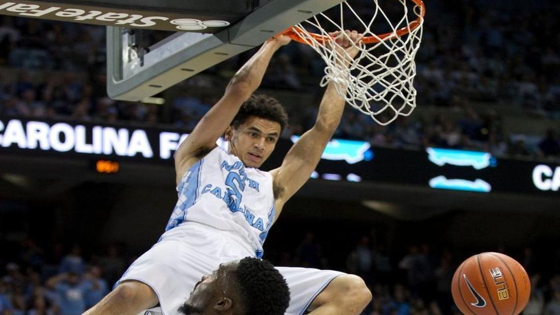 North Carolinas North Carolinas Marcus Paige (5) dunks over Clemson’s Gabe Devoe (10) and Landry Nnoko (35) in the second half to secure the Tar Heels 80-69 victory on Wednesday, December 30, 2015 at the Smith Center in Chapel Hill, N.C.