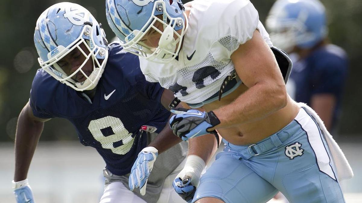 North Carolina linebacker Cole Holcomb and defensive back Patrice Rene (8) run through a drill during practice.