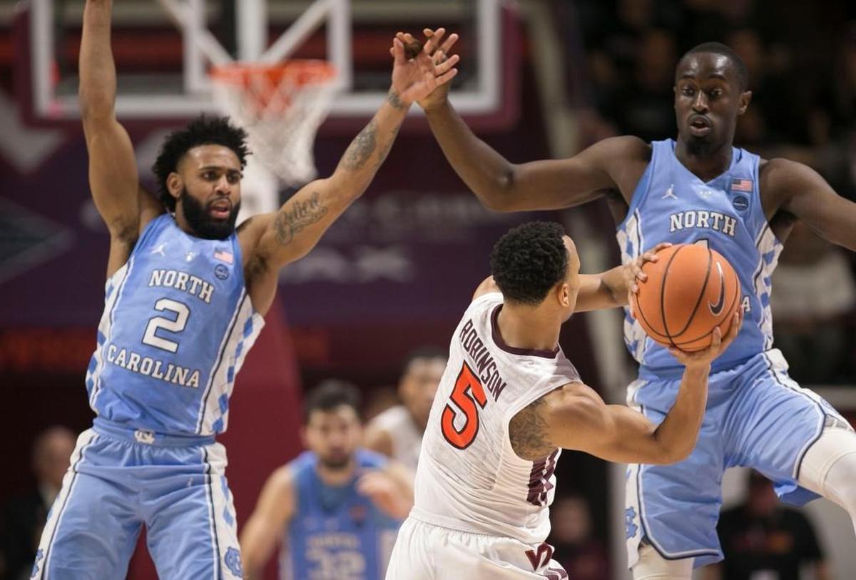 North Carolina’s Theo Pinson (1) and Joel Berry II (2) trap Virginia Tech’s Justin Robinson (5) during the second half on Monday, January 22, 2018 at Cassell Coliseum in Blacksburg, Virginia.