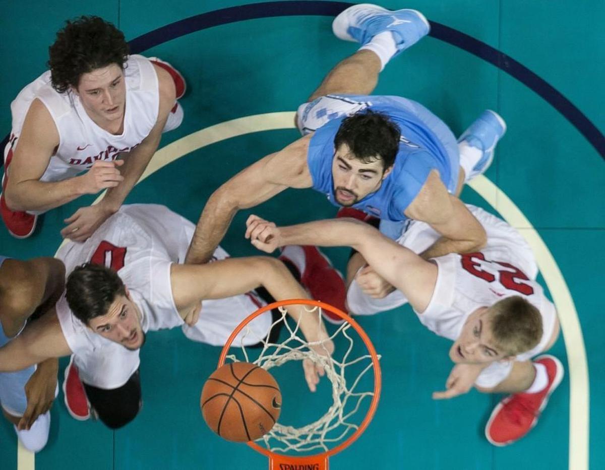North Carolina’s Luke Maye (32) watches his shot drop into the basket as he is blocked out by Davidson’s Dusan Kovacevic (0) and Peyton Aldridge (23) during the second half on Friday, December 1, 2017 at the Spectrum Center in Charlotte, N.C. Maye scored 24 points in the Tar Heels’ 85-75 victory.