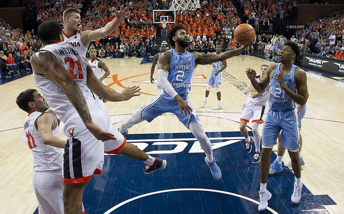 North Carolina’s Joel Berry II (2) splits the Virginia defense of Jack Salt (33), Isaiah Wilkins (21) and Ty Jerome (11) during the first half on Saturday, January 6, 2018 at John Paul Jones Arena in Charlottesville, Va.