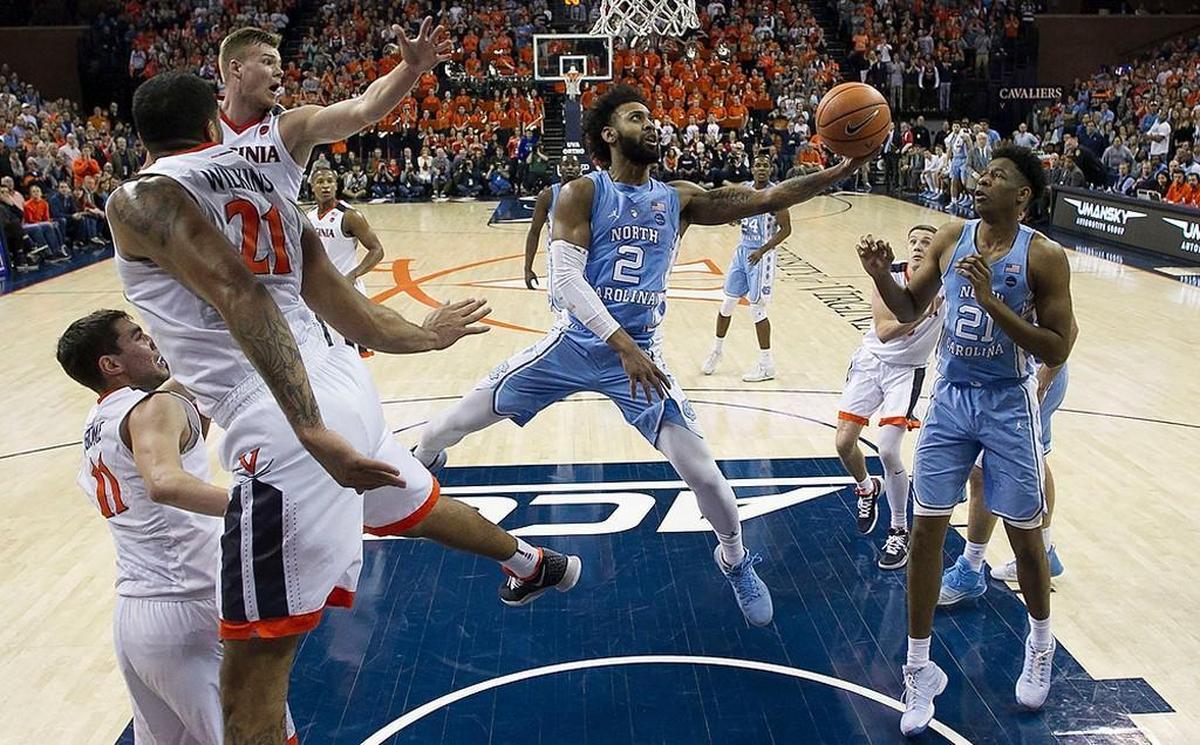 North Carolina’s Joel Berry II (2) splits the Virginia defense of Jack Salt (33), Isaiah Wilkins (21) and Ty Jerome (11) during the first half on Saturday, January 6, 2018 at John Paul Jones Arena in Charlottesville, Va.