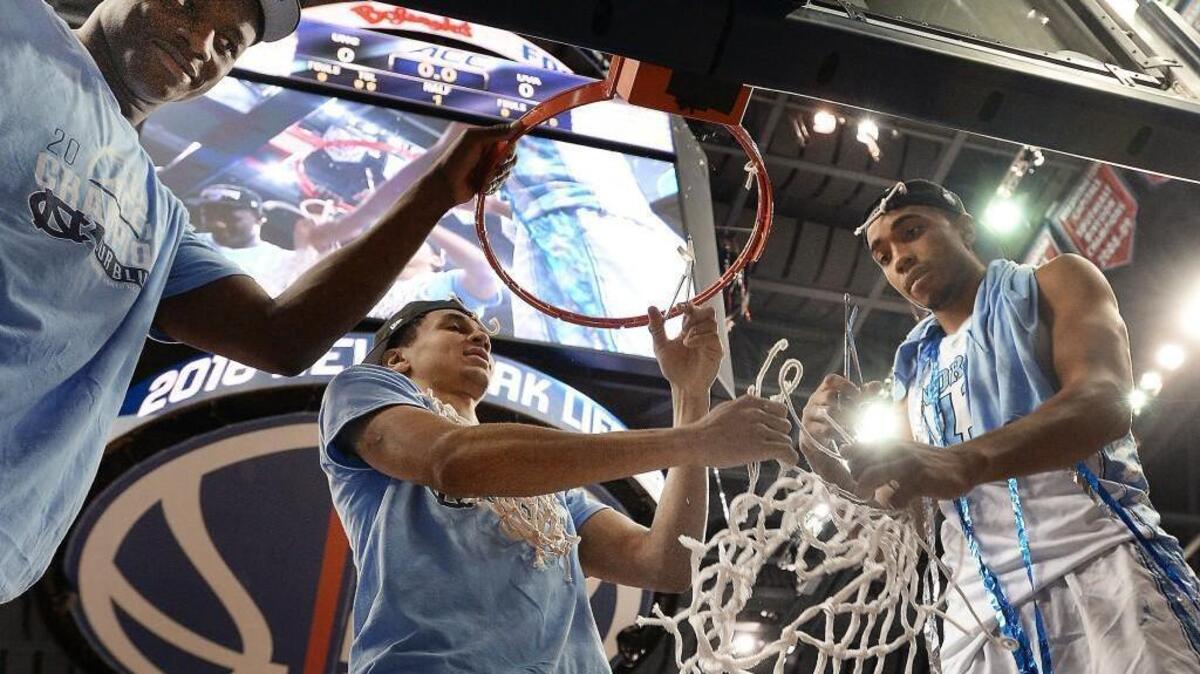 UNC forward Joel James, left, guard Marcus Paige, middle and forward Brice Johnson, right, cut the nets after the Tar Heel’s 61-57 win over Virginia in the ACC tournament championship game on March 12.