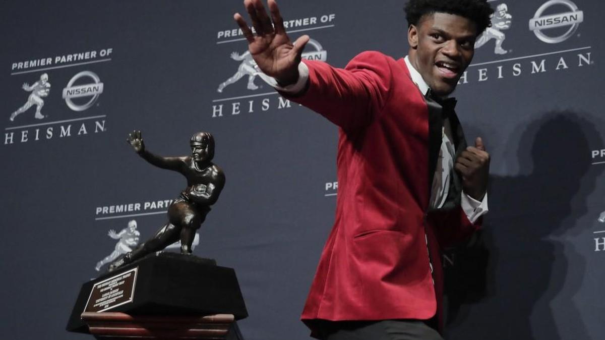 Louisville’s Lamar Jackson poses with the Heisman Trophy after winning the award on Dec. 10, 2016.