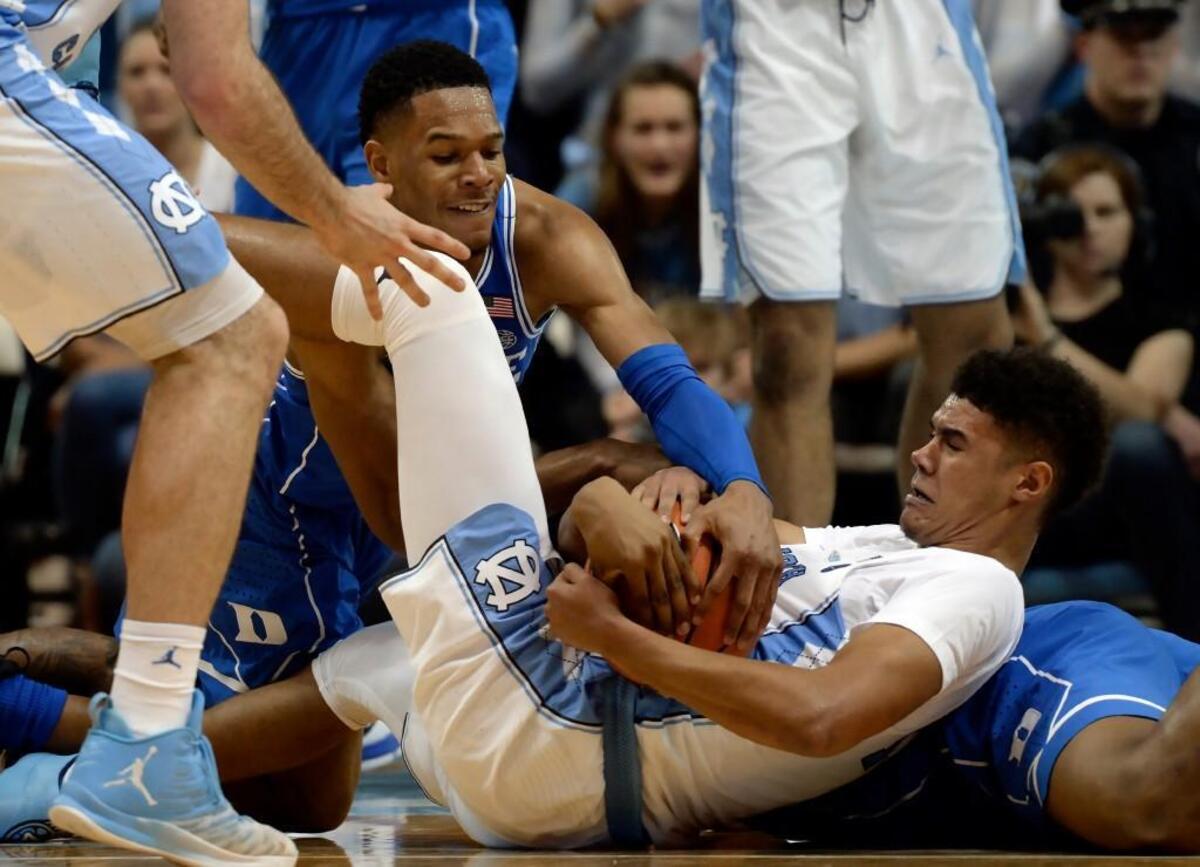 Duke guard Trevon Duval (1) and UNC guard Cameron Johnson (13) wrestle for a loose ball near games' end. UNC defeated Duke 82-78 at the Dean Smith Center in Chapel Hill, N.C. Thursday, Feb. 8, 2018.