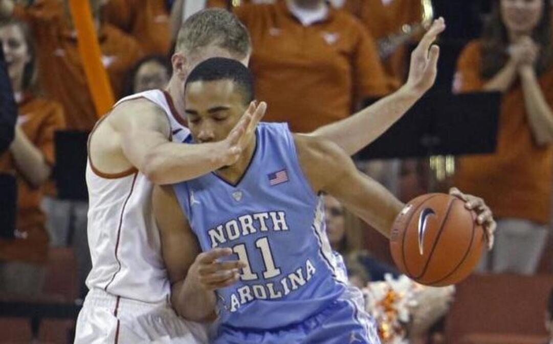 North Carolina forward Brice Johnson tries to dribble around Texas forward Connor Lammert on Saturday. Johnson finished the game with 12 points, but he also had three fouls that limited his playing time and effectiveness.