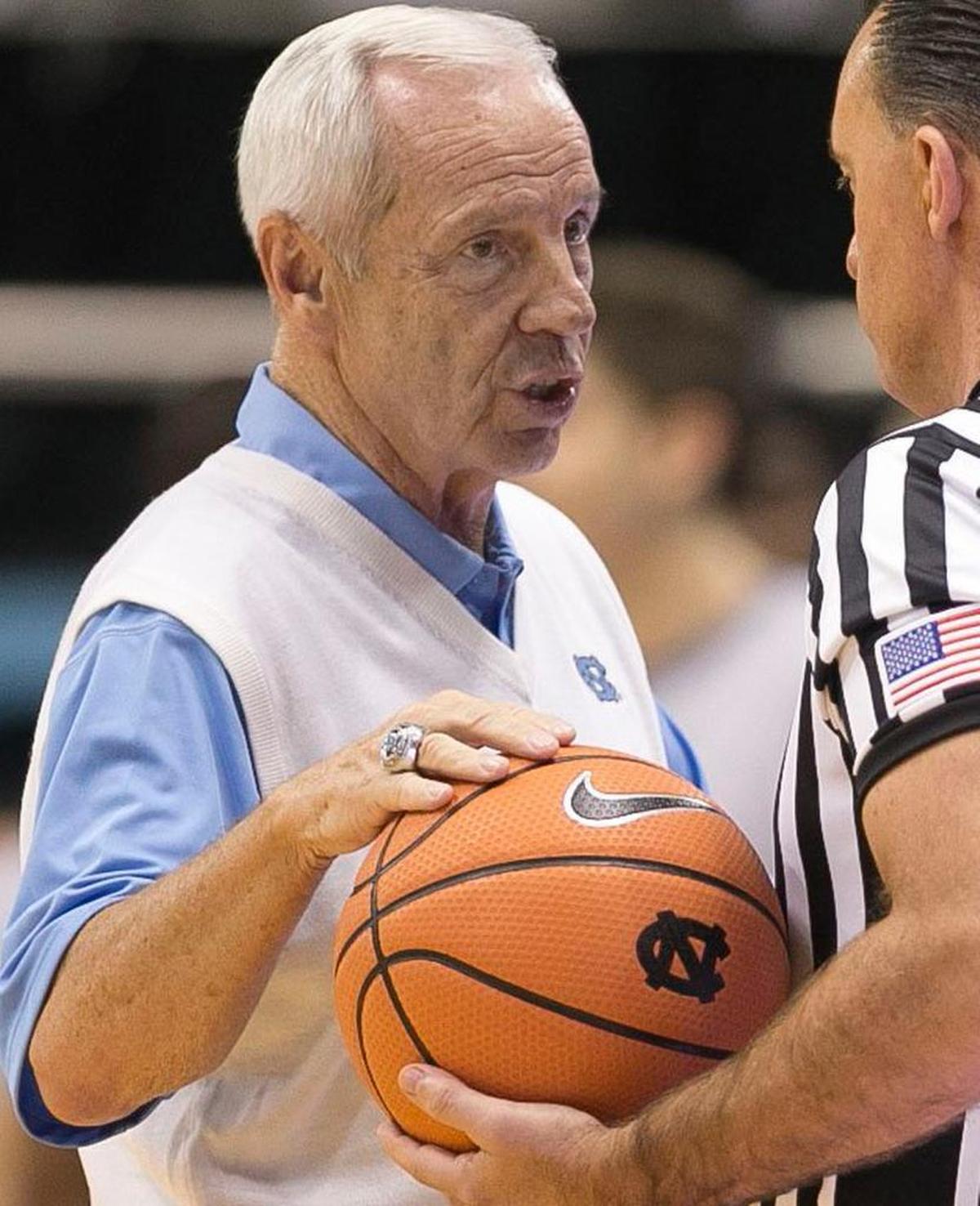 North Carolina coach Roy Williams talks with official Roger Ayers during a game earlier this season. The Nike swoosh logo adorns everything from the basketballs, clothing, uniforms, and shoes.