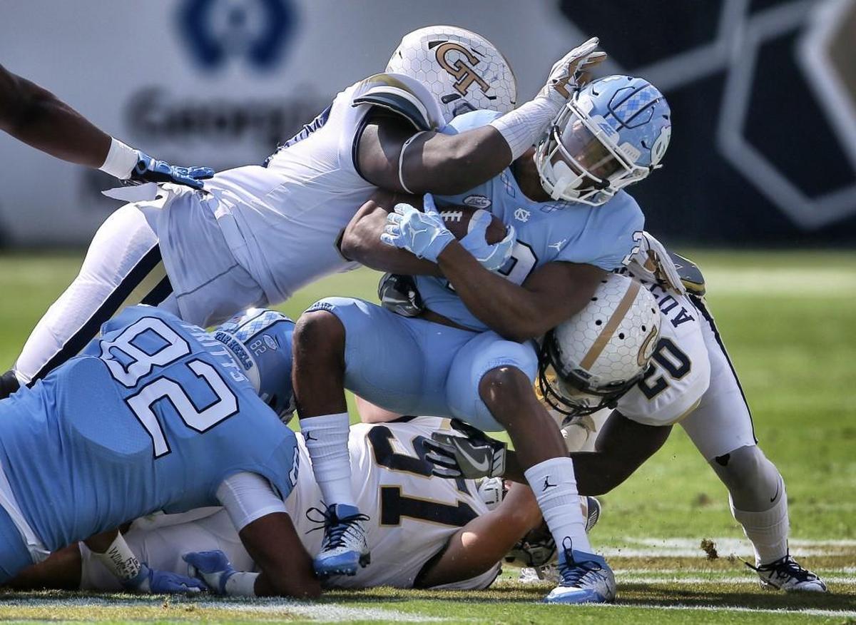 North Carolina running back Jordon Brown (2) is tackled by Georgia Tech linebacker Brant Mitchell (51) and Georgia Tech defensive back Lawrence Austin (20) in the first half.