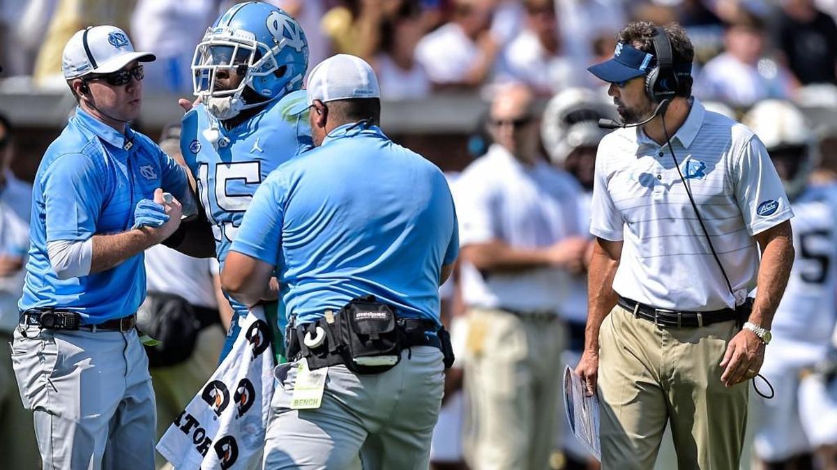 North Carolina head coach Larry Fedora watches as safety Donnie Miles (15) is helped off the field during the second half.