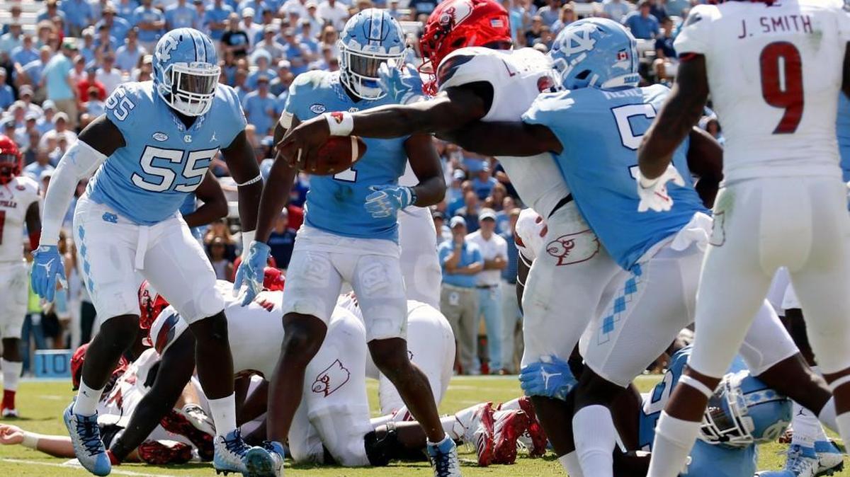 Louisville's Lamar Jackson (8) reaches over the goal line to score a TD during the fourth quarter in a game between UNC and Louisville at Kenan Stadium in Chapel Hill on Sept. 9, 2017. Jason Strowbridge (55), Myles Dorn (1) and Patrice Rene (5) defend for the Tar Heels.