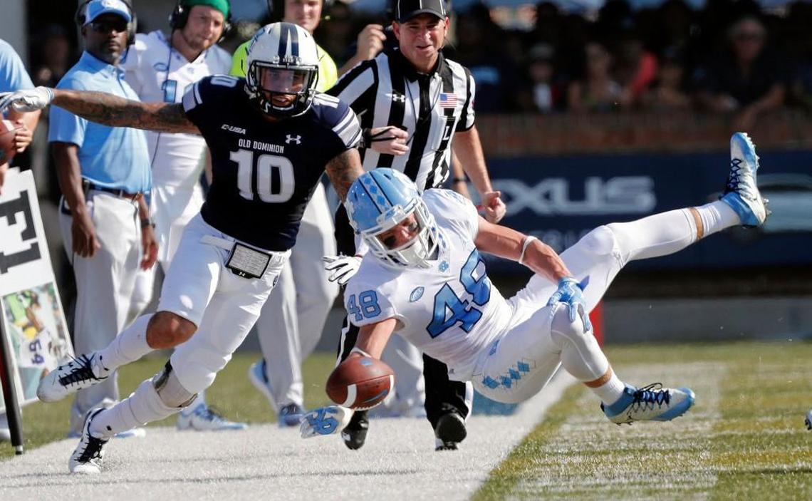 UNC's Thomas Jackson (48) flies through the air as he is upended by ODU's Andre Bernhard (10) during the first quarter.