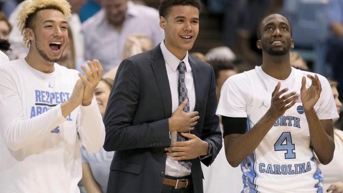 North Carolina’s Cameron Johnson (13), center, out with an injury, applauds his teammates during the second half against Michigan on November 29, 2017 at the Smith Center in Chapel Hill. Johnson is recovering following knee surgery two weeks ago.
