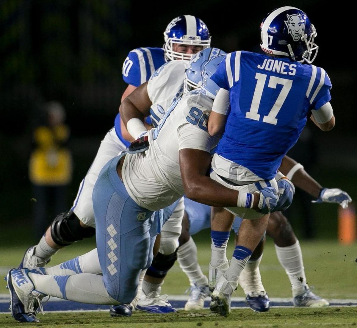 Duke quarterback Daniel Jones, right, is sacked by UNC’s Nazair Jones (90) in November.