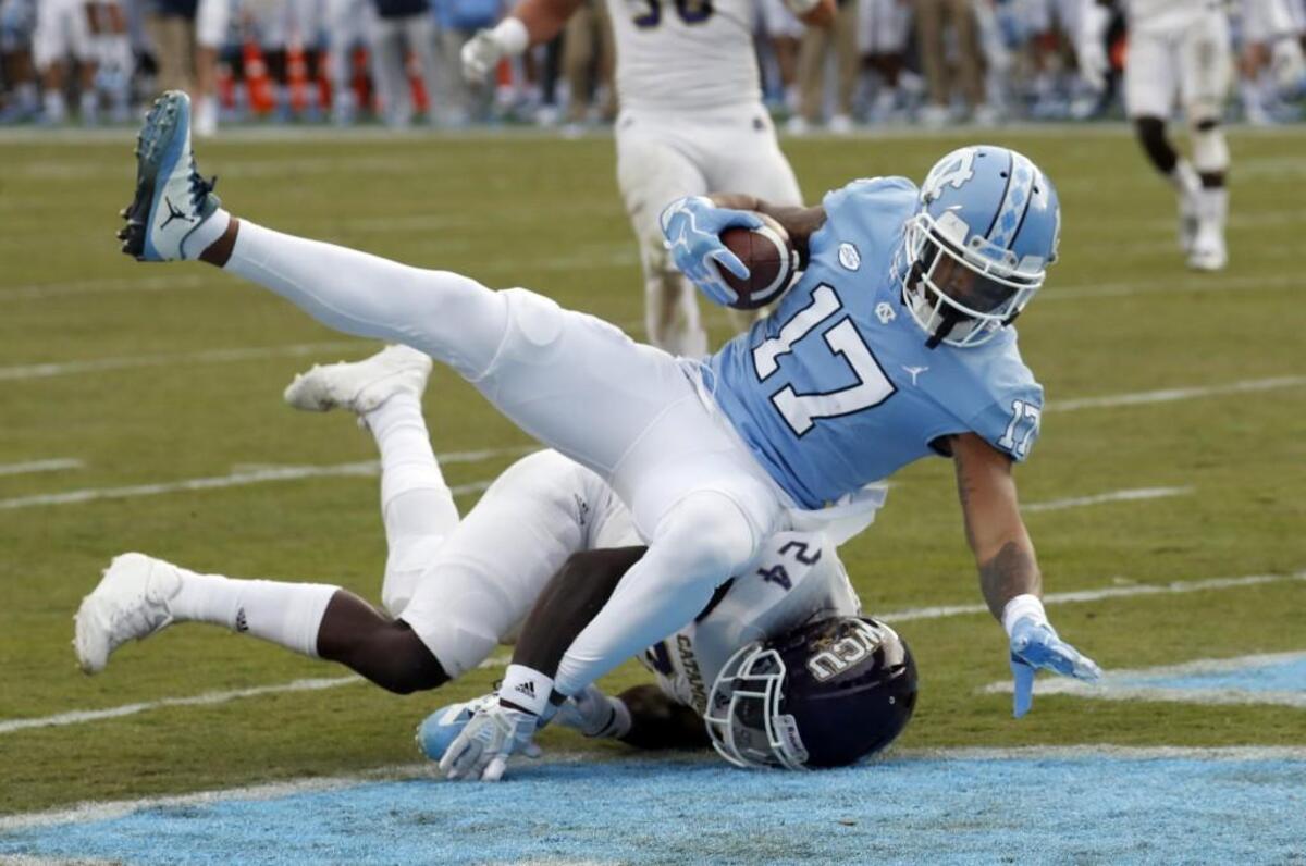 UNC’s Anthony Ratliff-Williams (17) tumbles over WCU’s Shamon Elliott (24) for a touchdown during the first quarter.