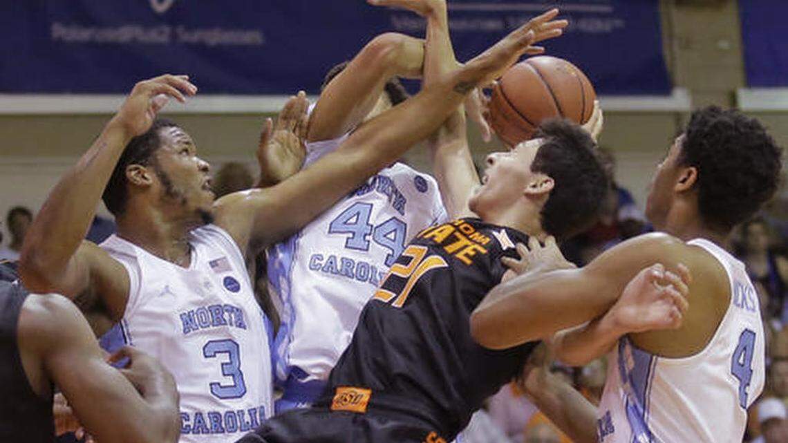 Oklahoma State guard Lindy Waters III (21) battles with North Carolina's Kennedy Meeks (3), Justin Jackson (44) and Isaiah Hicks (4) for a rebound during the first half of an NCAA college basketball game in the Maui Invitational on Tuesday, Nov. 22, 2016, in Lahaina, Hawaii.