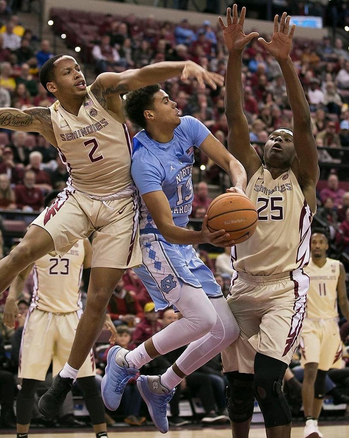 Florida State’s C.J. Walker (2) and Mfiondu Kabegnele (25) trap North Carolina’s Cameron Johnson (13) under the basket during the first half on Wednesday, January 3, 2018 at the Tucker Civic Center in Tallahassee,