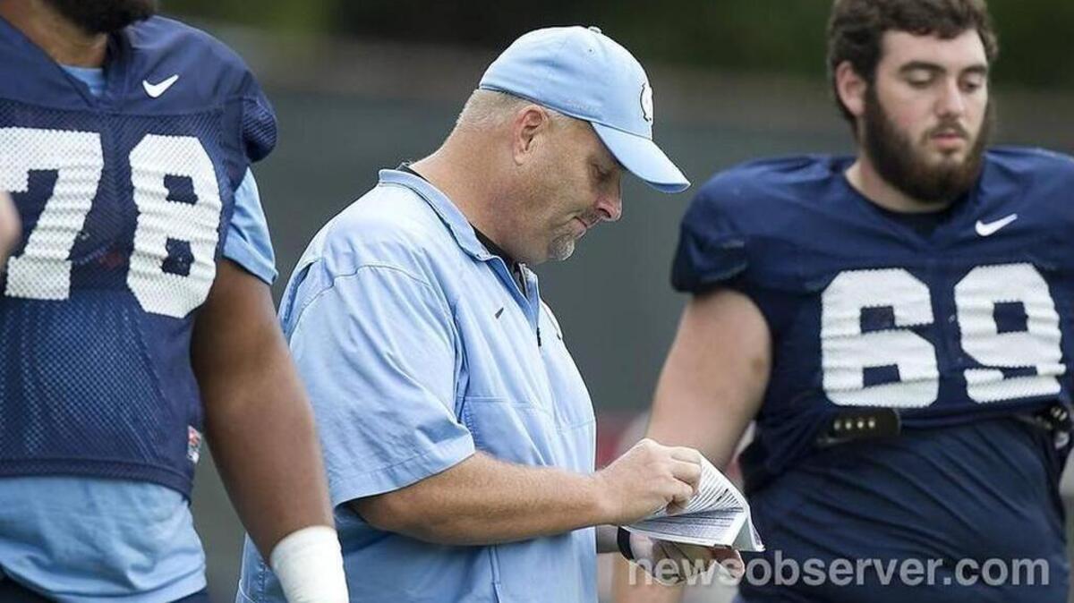 Chris Kapilovic, center, is entering is first season in a dual role as the Tar Heels’ offensive line coach and offensive coordinator.