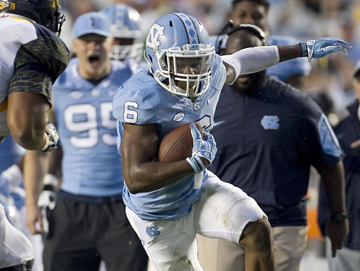 North Carolina’s M.J. Stewart, middle, returns the ball 15 yards after intercepting a pass by North Carolina A&T’s Kwashuan Quick in 2015.