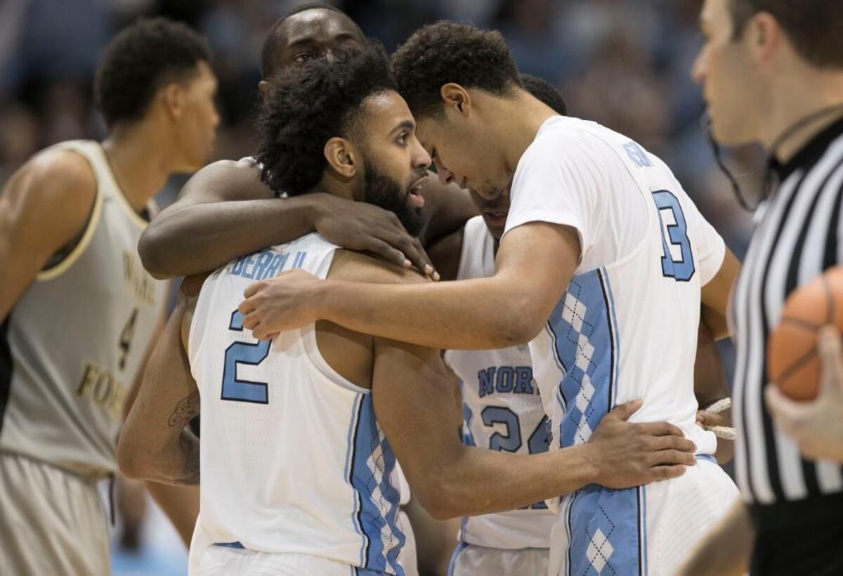 North Carolina’s Joel Berry II (2) huddles with teammates Theo Pinson (1), Kenny Williams (24) and Cameron Johnson (13) during the closing minutes of the second half on Saturday, December 30, 2017 at the Smith Center in Chapel Hill, N.C.