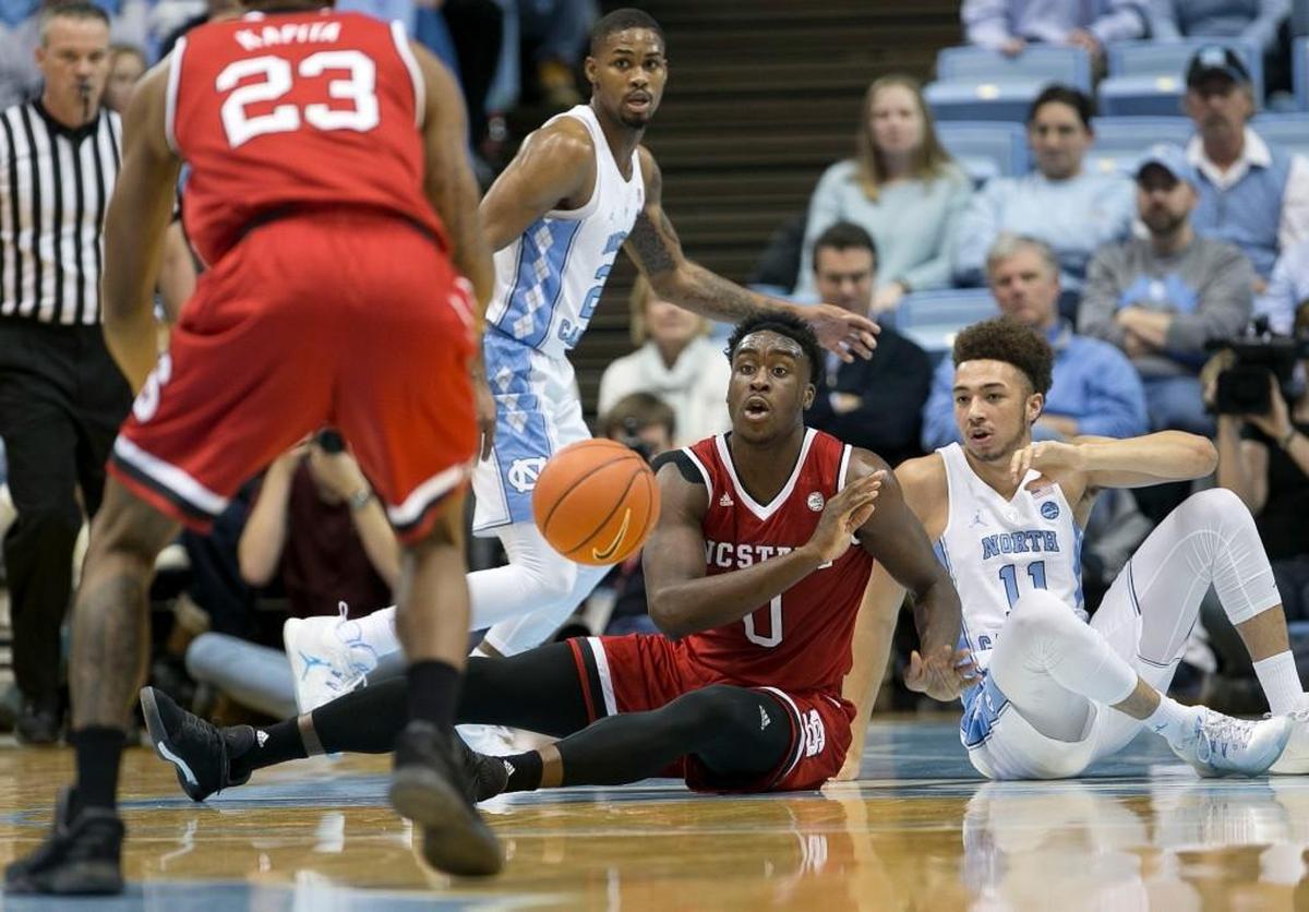 N.C. State’s Abdul-Malik Abu, middle on floor, looks for an open teammate after recovering a loose ball on Jan. 8, 2017.