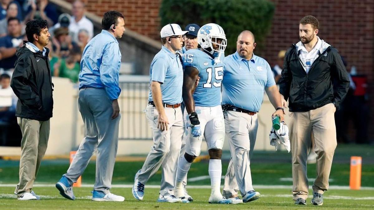 North Carolina safety Donnie Miles (15) is escorted off the field after being injured during the second half of Notre Dame's 33-10 victory over UNC at Kenan Stadium in Chapel Hill, NC Saturday, Oct. 7, 2017.