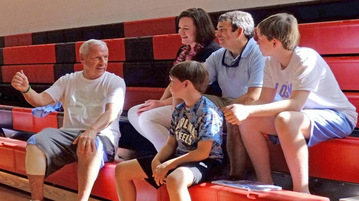 UNC coach Roy Williams (left) spends time with Will Fickling, right, and his family during the Tar Heels’ shoot-around at Lahainalula High School on Monday, Nov. 21, 2016. Will is receiving treatment for a brain tumor, and Make-A-Wish Eastern North Carolina granted his wish to attend the Maui Invitational with his family.