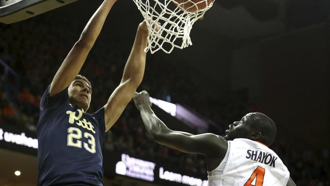 Pittsburgh guard Cameron Johnson, left, dunks over Virginia guard Marial Shayok in March.