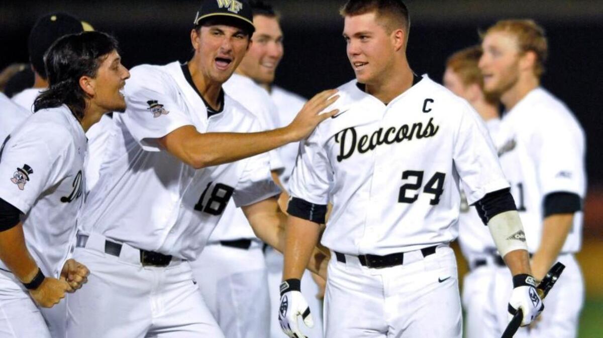 Wake Forest’s Bobby Hearn, left, and Carter Bach, center, congratulate Gavin Sheets after his game-winning hit against West Virginia on June 3.