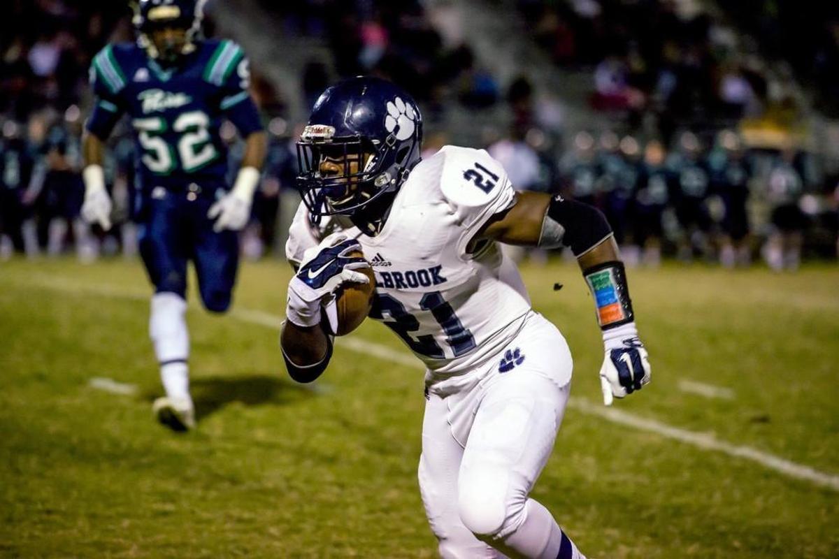 Millbrook’s Marcus Marshall (21) finds an open hole in Leesville defense on Oct. 31, 2014 at Leesville Road in Raleigh.