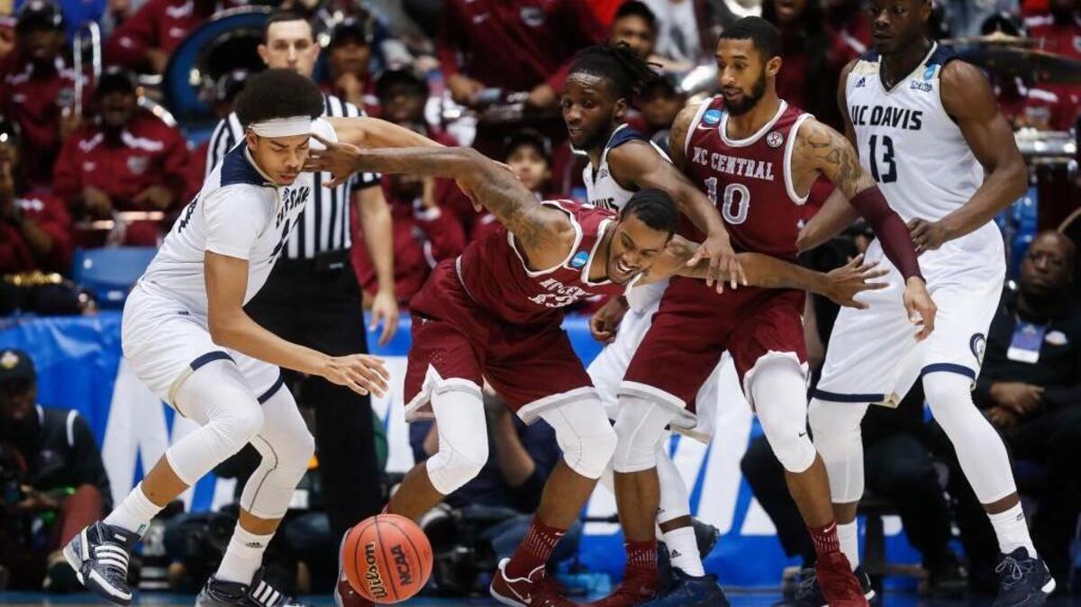 North Carolina Central's Pablo Rivas, center, and UC Davis' Garrison Goode, left, scramble for ball during the second half of First Four game in the NCAA tournament on March 15, 2017, in Dayton, Ohio. UC Davis won 67-63. (AP Photo/John Minchillo)