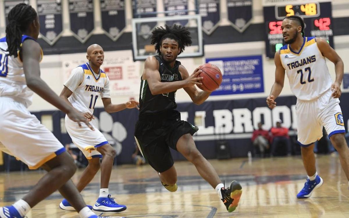 Coby White (0) of Greenfield dribbles between Sal-Bay Young, left, Marque Maultsby (10) and Kenyon Burt (22) of Garner. The Greenfield School Knights played the Garner Trojans in the Millbrook Showcase high school boys basketball event on Dec. 2, 2017.