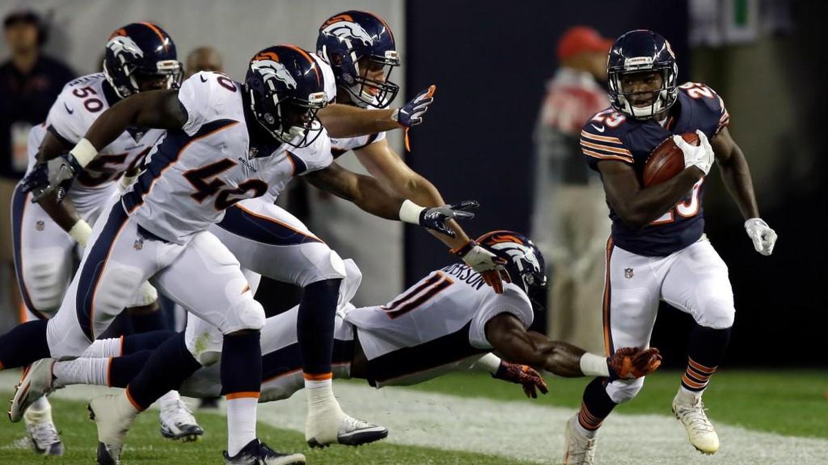 Chicago Bears running back Tarik Cohen, right, runs against the Denver Broncos’ defense on Aug. 10.