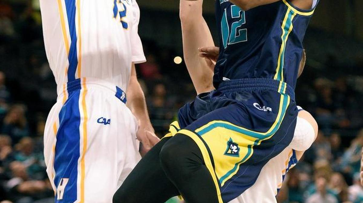 UNC Wilmington guard C.J. Bryce (12) goes to the basket against Hofstra forward Denton Koon, left, and Brian Bernardi, center back, and Andre Walker (44) during the first half of an NCAA college basketball game in the Colonial Athletic Association championship, Monday, March 7, 2016, in Baltimore.