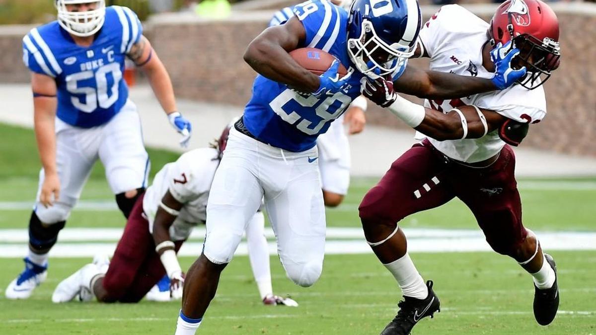 Duke running back Shaun Wilson, middle, stiff-arms NC Central defensive back Alden McClellon on Saturday.